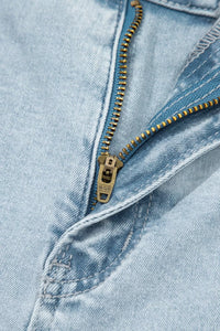 Close-up of a zipper on a pair of light blue jeans