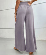 Person wearing light purple wide-leg pants on a plain background
