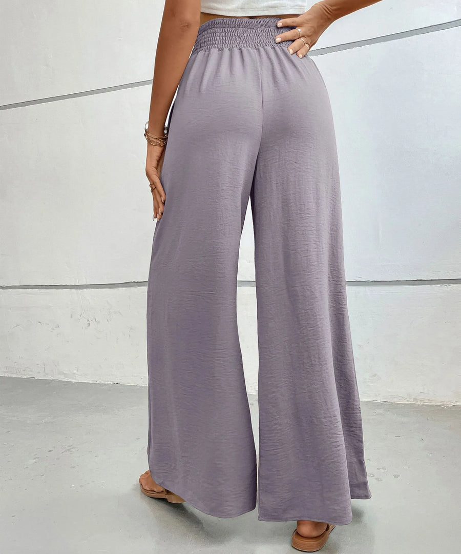Person wearing light purple wide-leg pants on a plain background