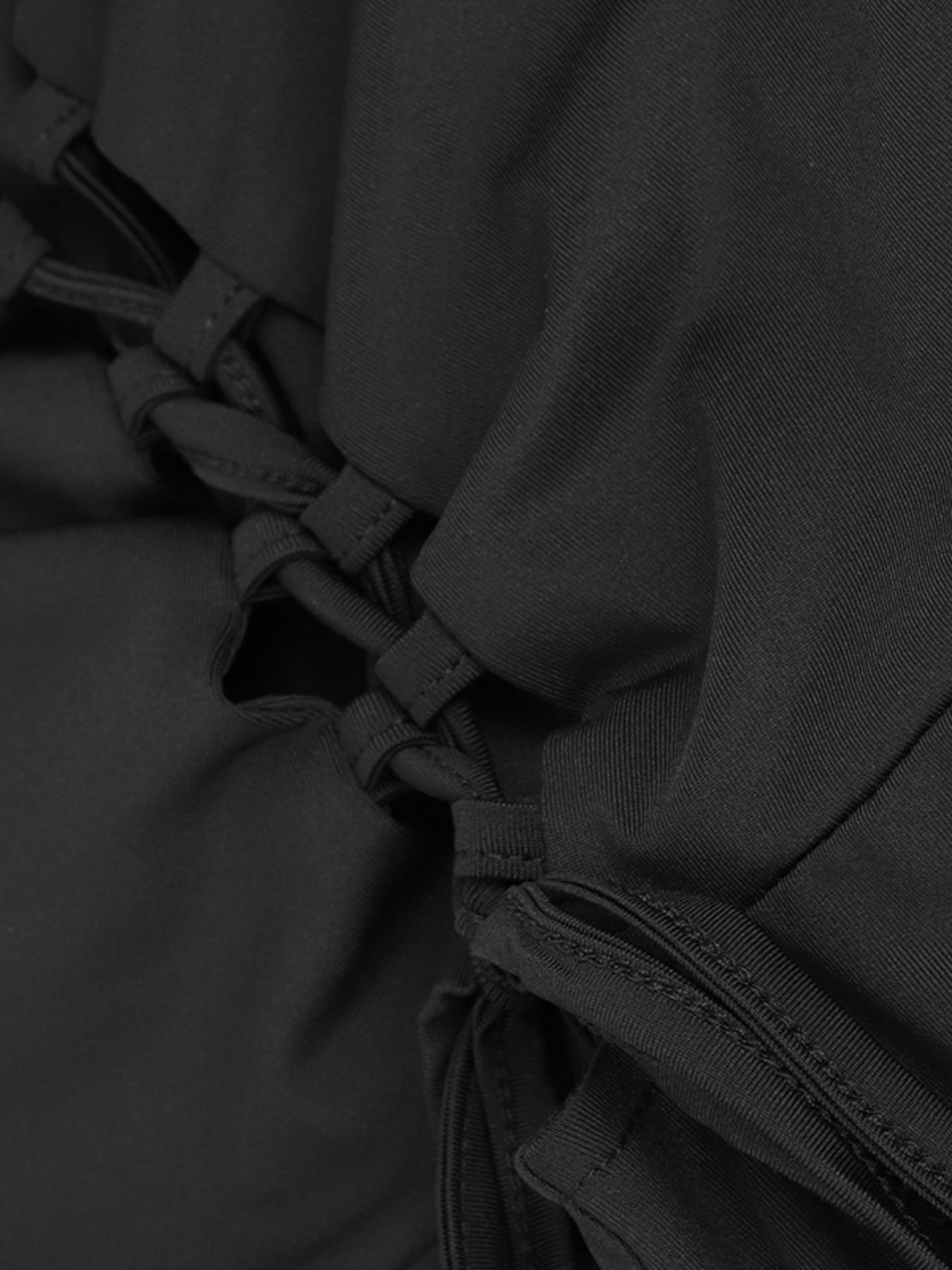 Close-up of a black garment with lace-up details