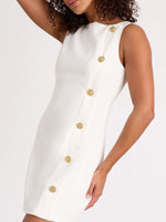 White dress with gold buttons worn by a model on a white background