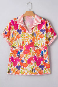 Colorful floral blouse on a hanger against a gray background