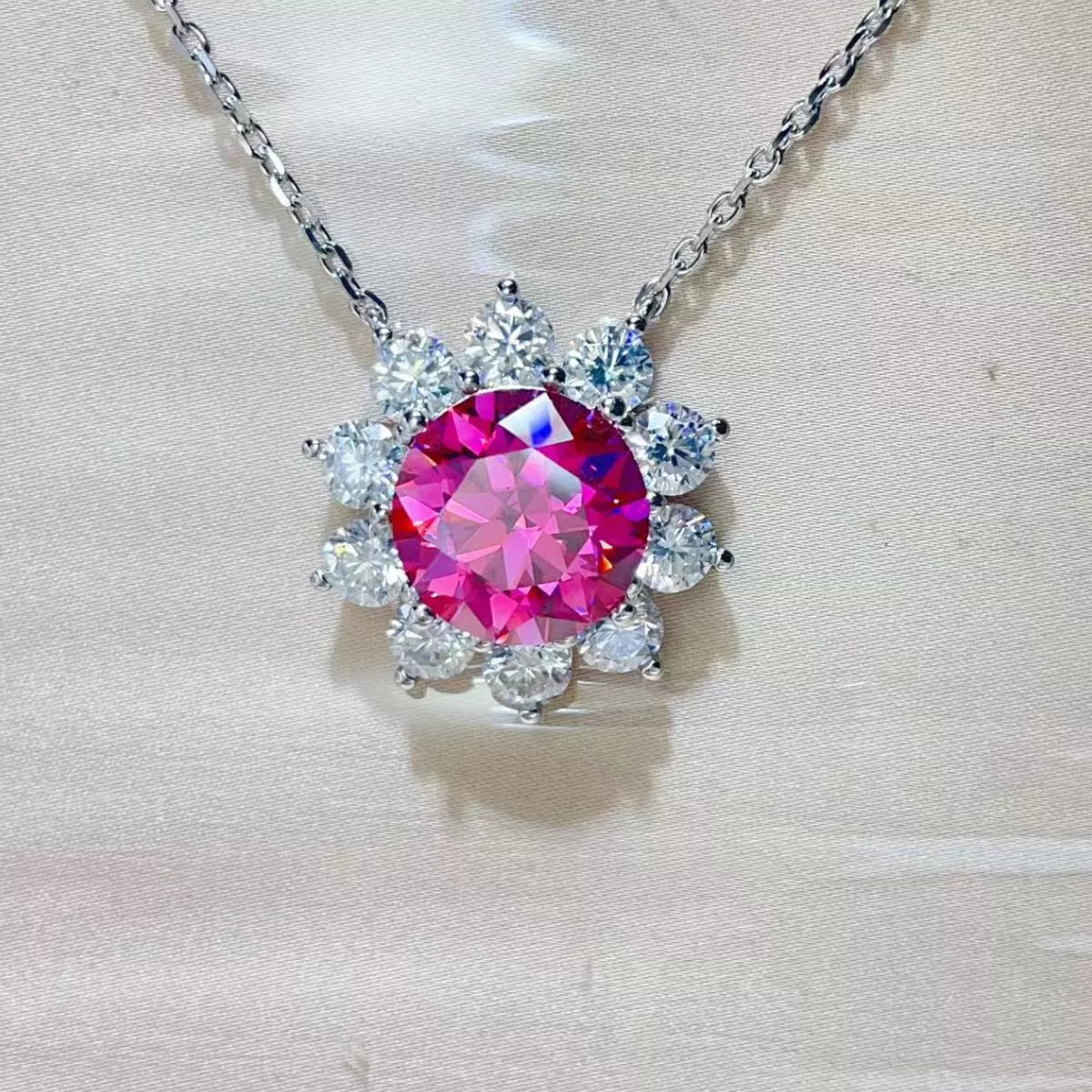 Necklace with a pink gemstone and silver chain on a light background