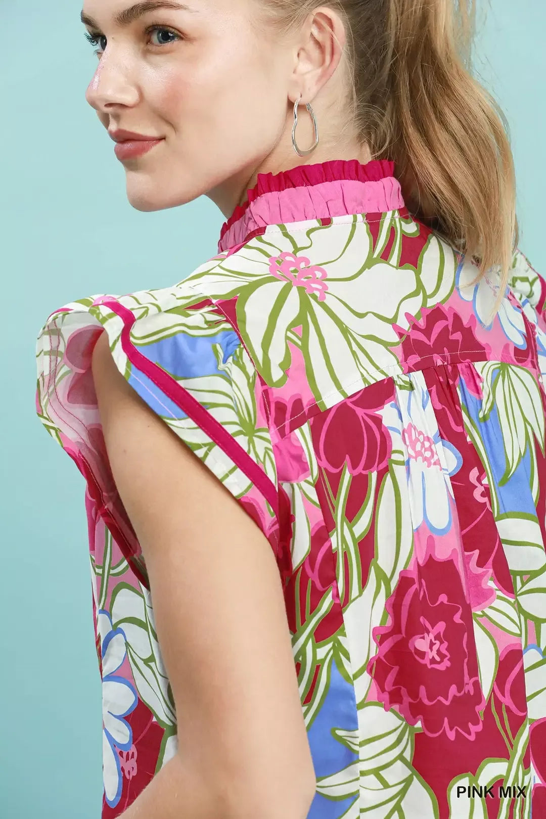 Woman wearing a colorful floral blouse with a light blue background