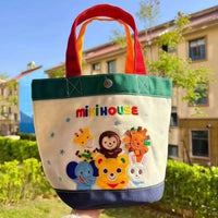 Colorful children's tote bag with animal designs and 'mikihouse' branding outdoors.