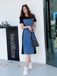Woman wearing a black and blue dress with white sneakers standing in front of a store entrance.