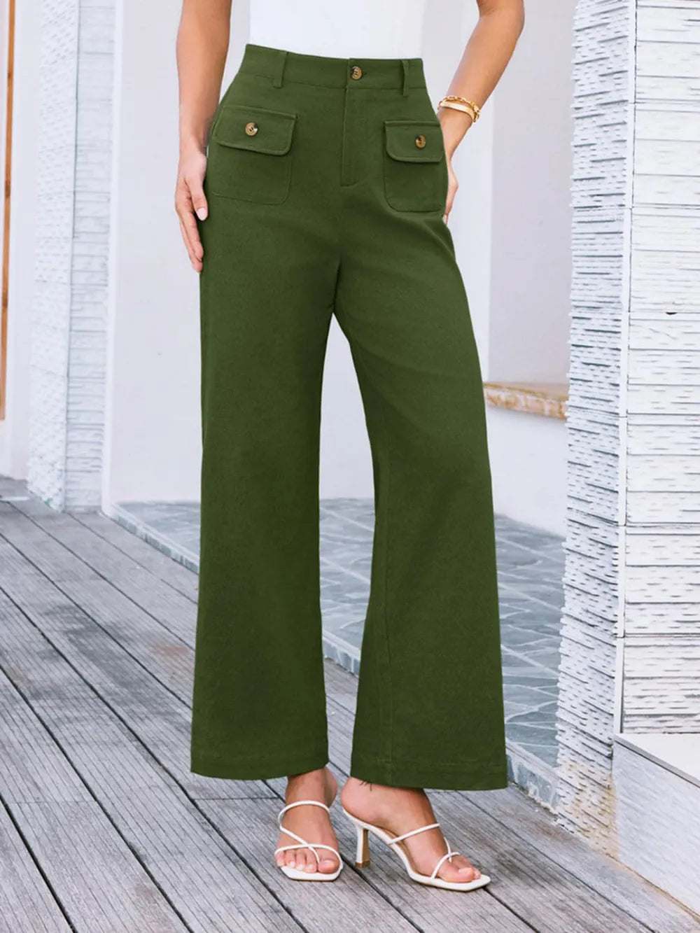 Person wearing green pants standing on a wooden deck.
