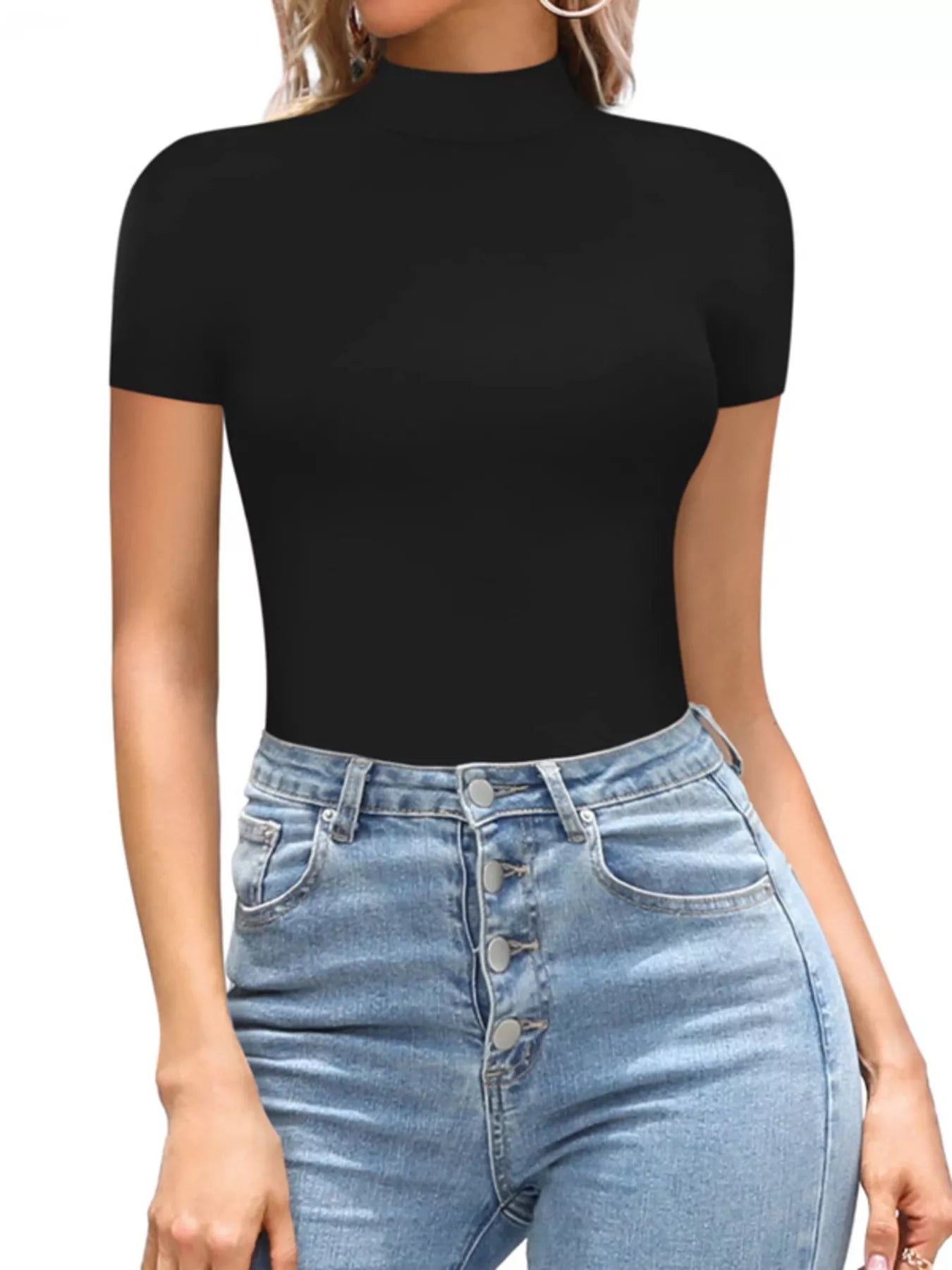 Person wearing a black short-sleeve top and blue jeans on a white background