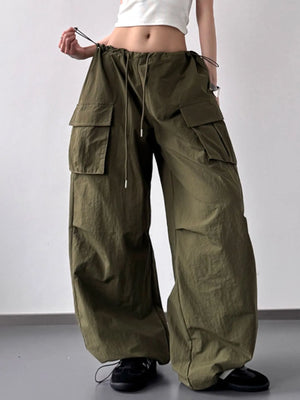 Person wearing olive green cargo pants on a plain background
