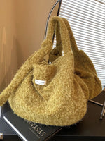Yellow textured handbag on a black surface with a blurred background