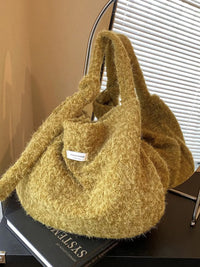 Yellow textured handbag on a black surface with a blurred background
