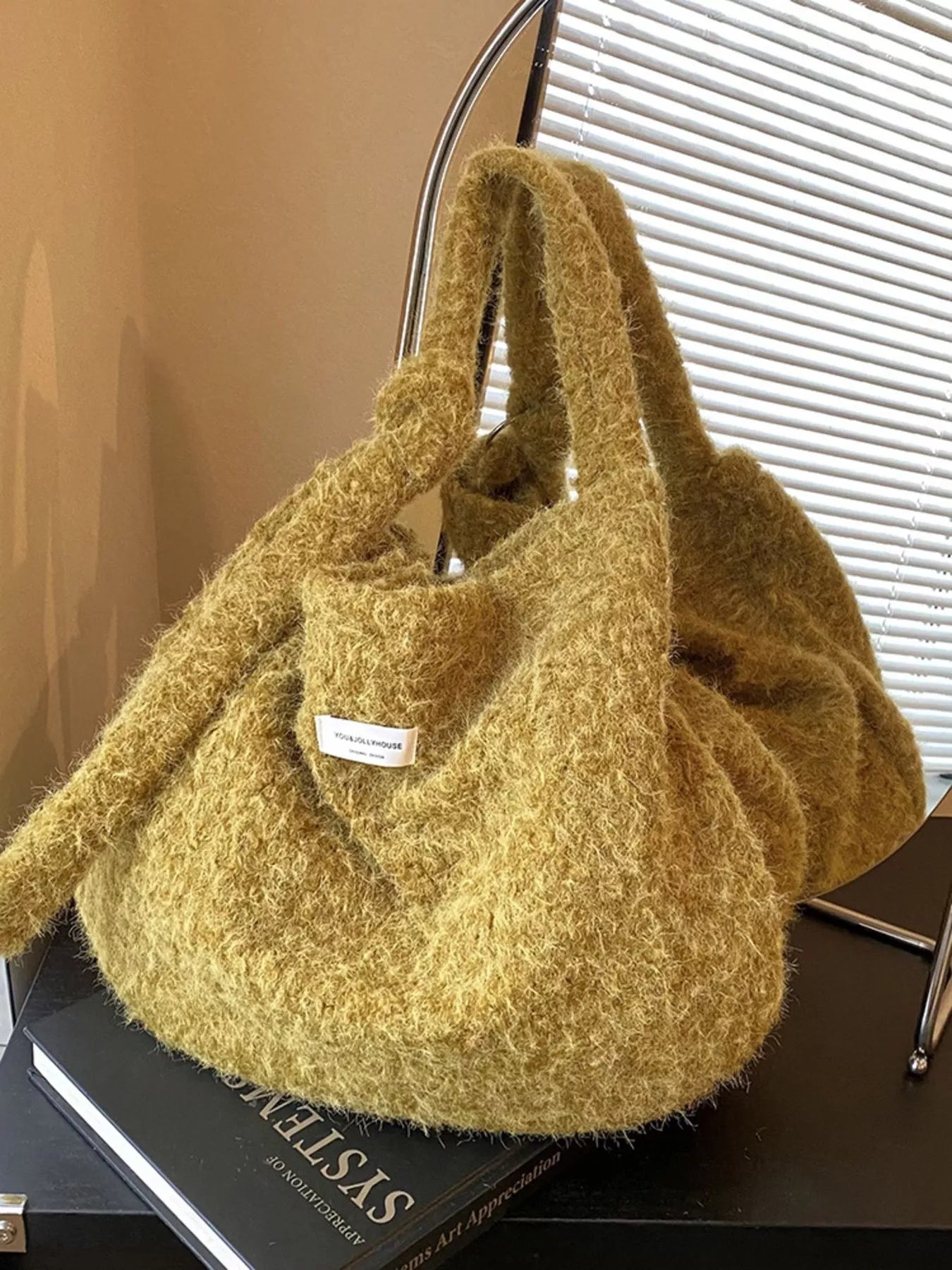 Yellow textured handbag on a black surface with a blurred background
