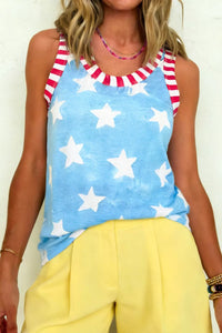 Woman wearing a sleeveless top with star pattern and yellow pants.
