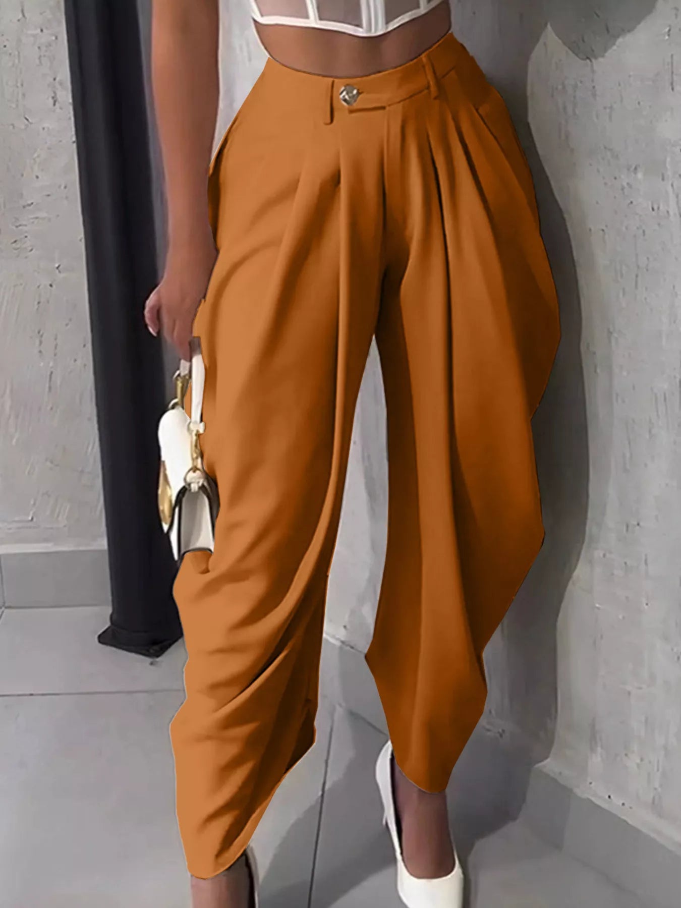 Person wearing orange high-waisted pants with a blurred background