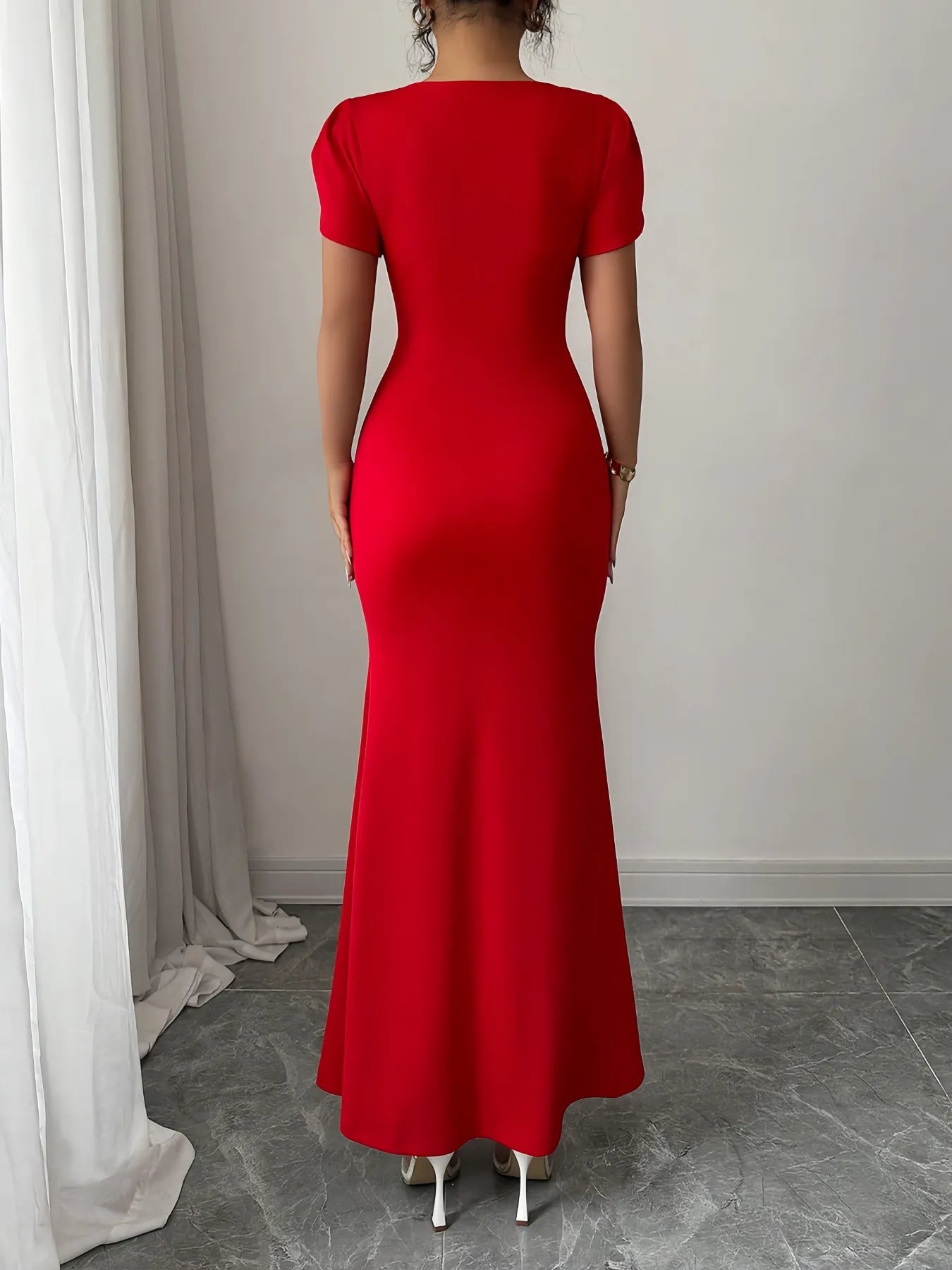 Red dress worn by a person standing against a neutral background