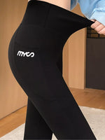 Black high-waisted leggings with a white 'mves' logo on the side pocket, shown on a model in an indoor setting.