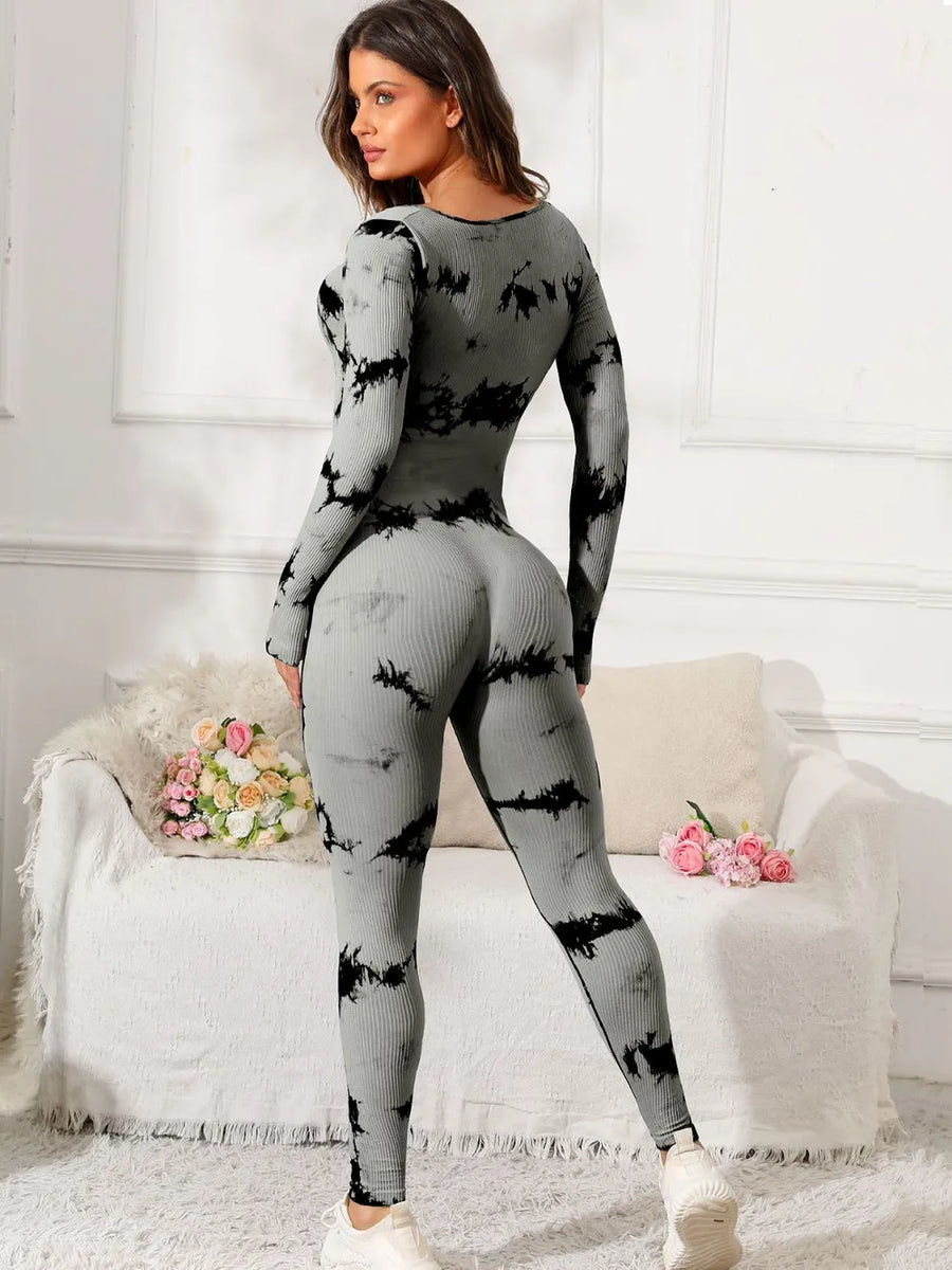Woman wearing a black and gray tie-dye outfit in a white room.