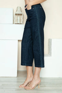 Person wearing dark blue wide-leg jeans with a neutral background