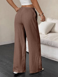 Person wearing brown wide-leg pants in a living room setting