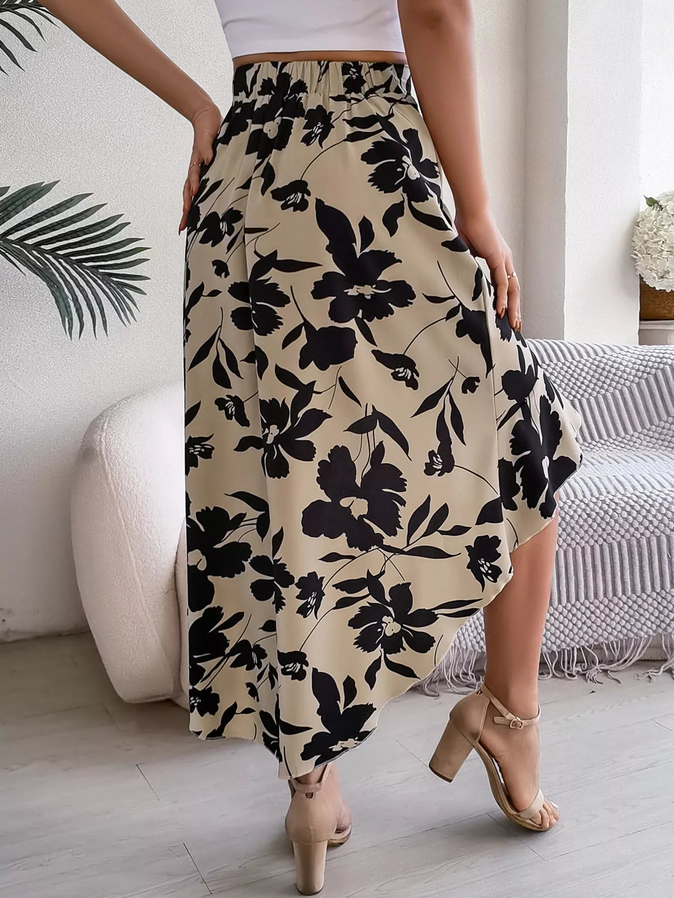 Person wearing a floral skirt with a neutral background