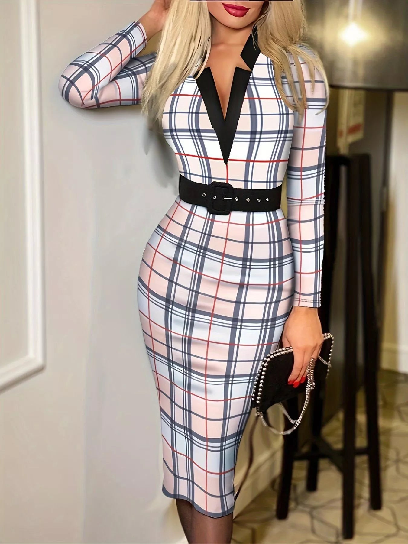 Woman wearing a plaid dress with a belt in an indoor setting