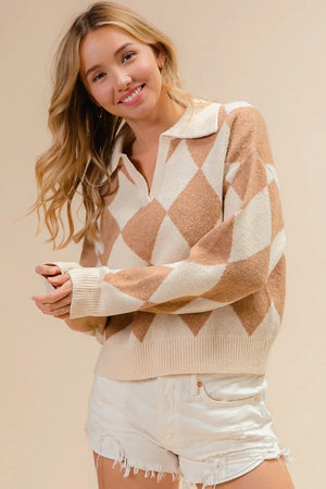 Woman wearing a beige and white patterned sweater with white shorts on a beige background