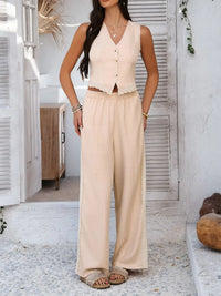 Woman wearing a beige sleeveless top and wide-leg pants in an outdoor setting.