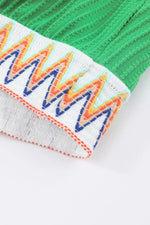 Close-up of colorful zigzag pattern on a green and gray background