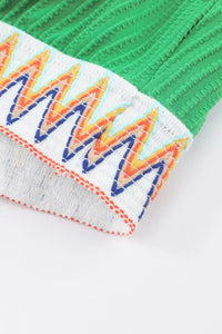 Close-up of colorful zigzag pattern on a green and gray background