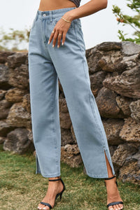 Person wearing light blue jeans with a stone wall and grass background