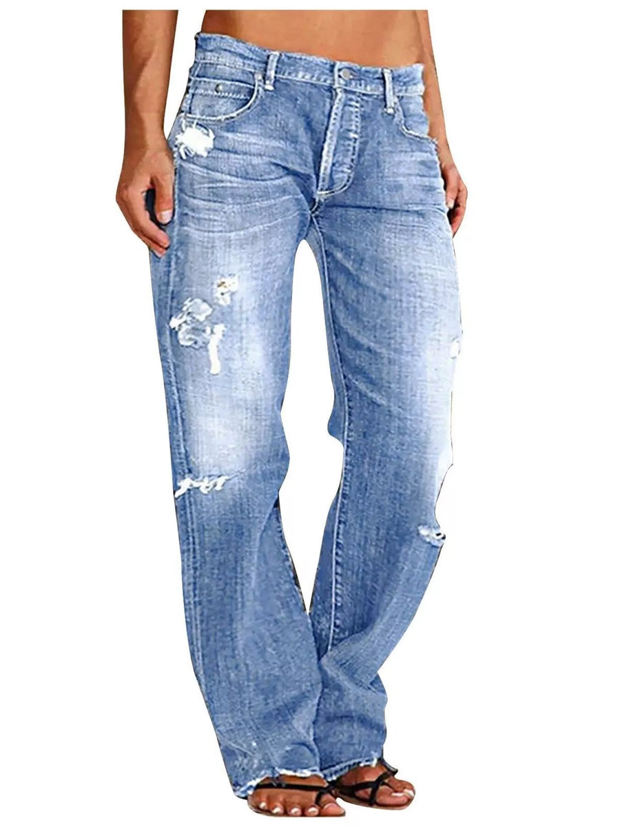 Blue distressed jeans worn by a person on a white background