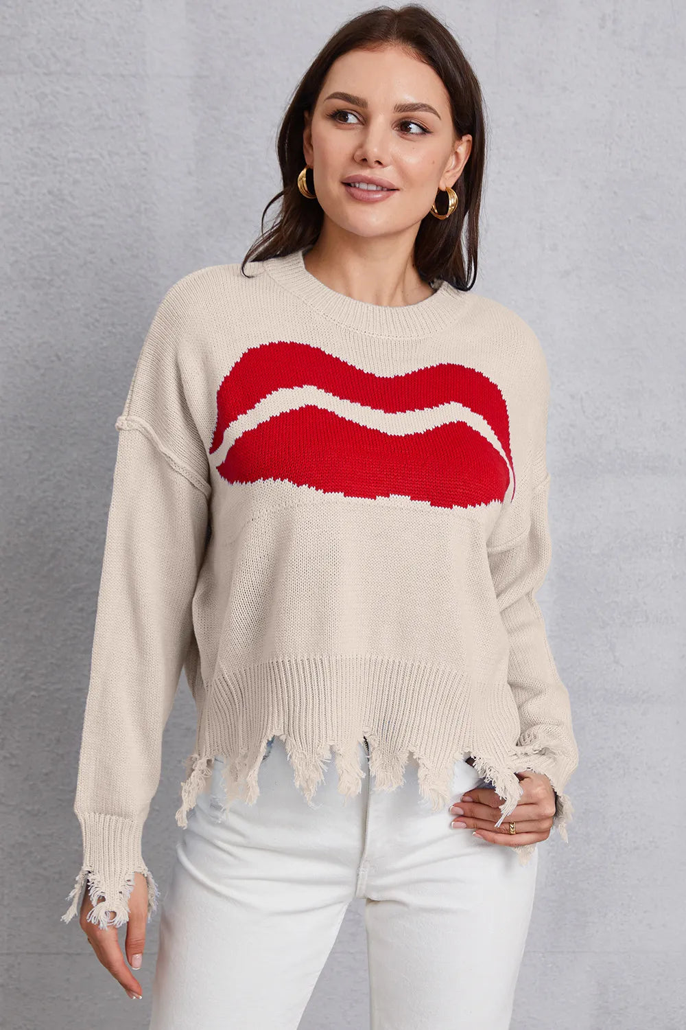 Woman wearing a beige sweater with a red lip design on a gray background