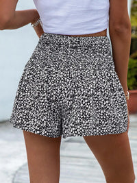 Person wearing a black and white floral skirt with a blurred background