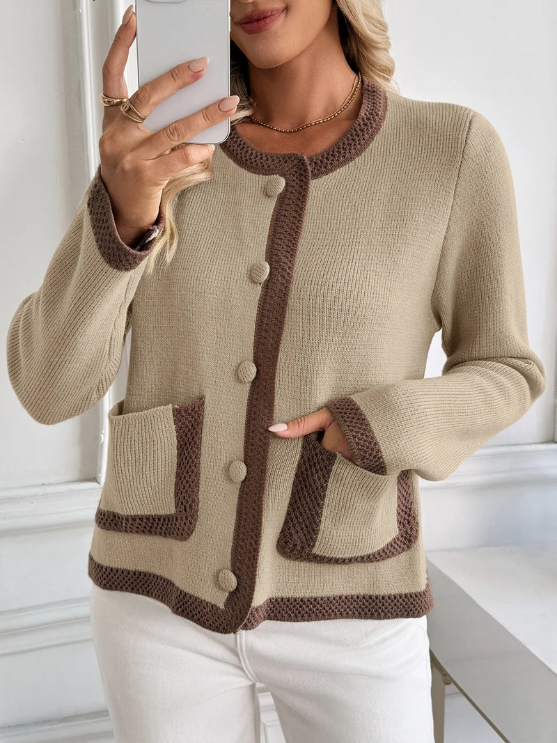 Woman wearing a beige cardigan with brown accents, taking a selfie.