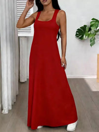 Woman wearing a red dress in a room with white walls and a plant.