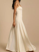 White spaghetti strap dress on a beige background