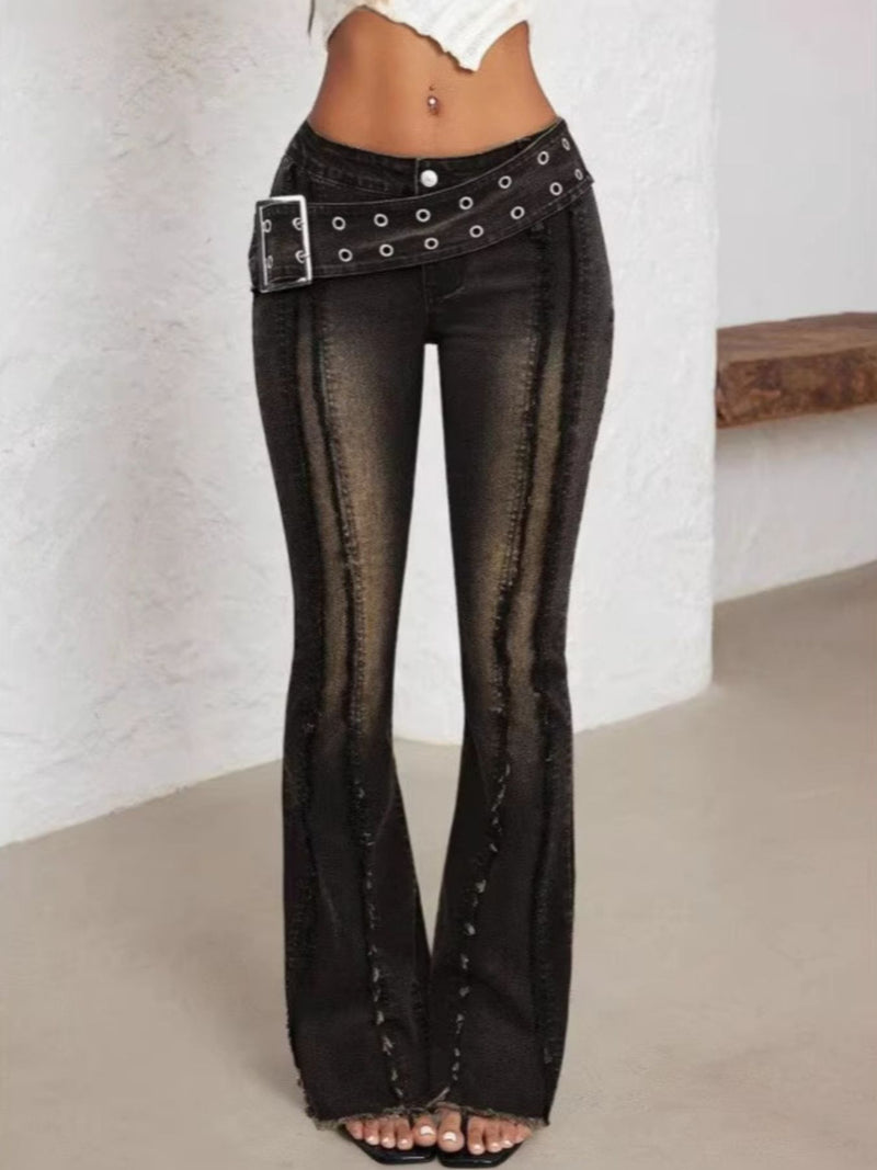 Black flared jeans with a belt on a plain background