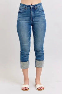 Blue jeans with rolled-up cuffs on a white background