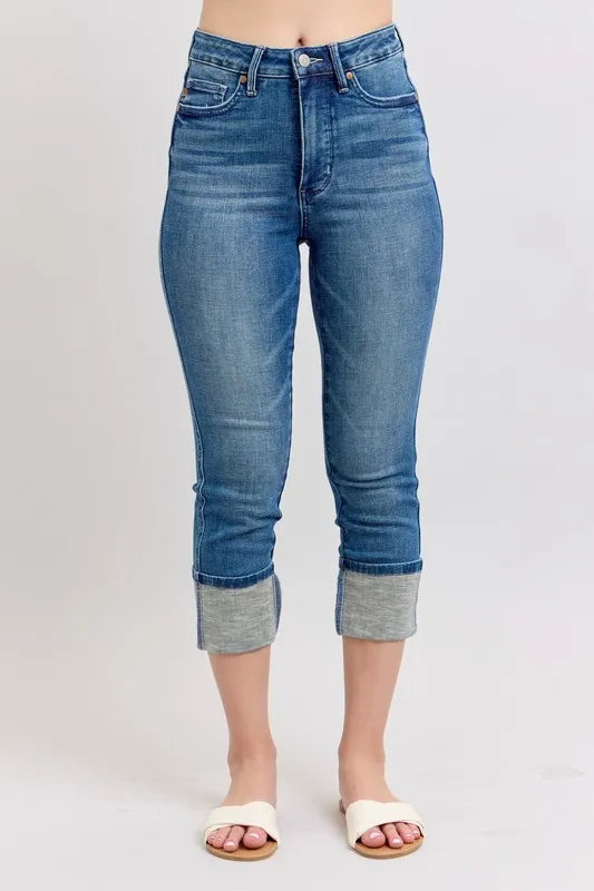Blue jeans with rolled-up cuffs on a white background