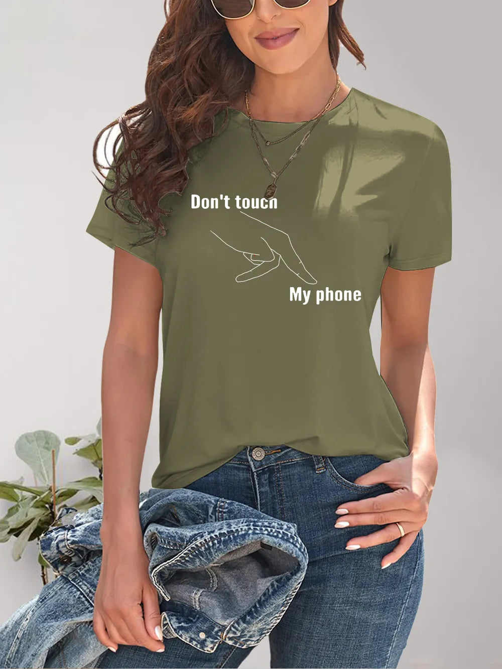 Person wearing a green t-shirt with text 'Don't touch my phone' against a plain background