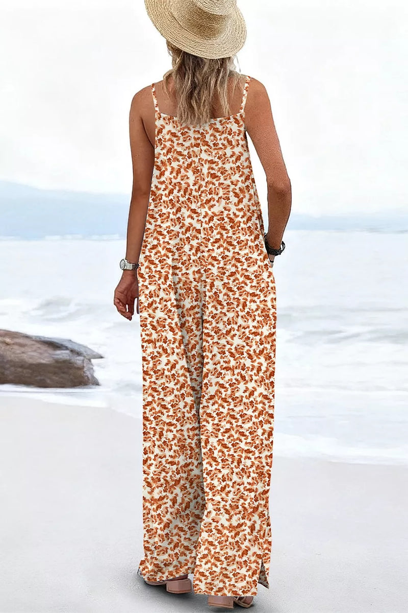Person wearing a long floral dress and straw hat on a beach.