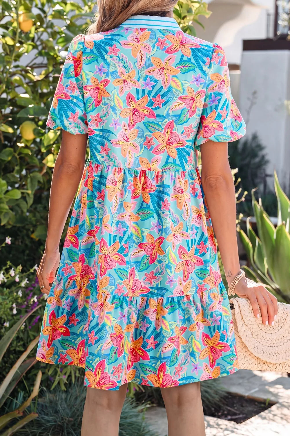Woman wearing a colorful floral dress in an outdoor setting