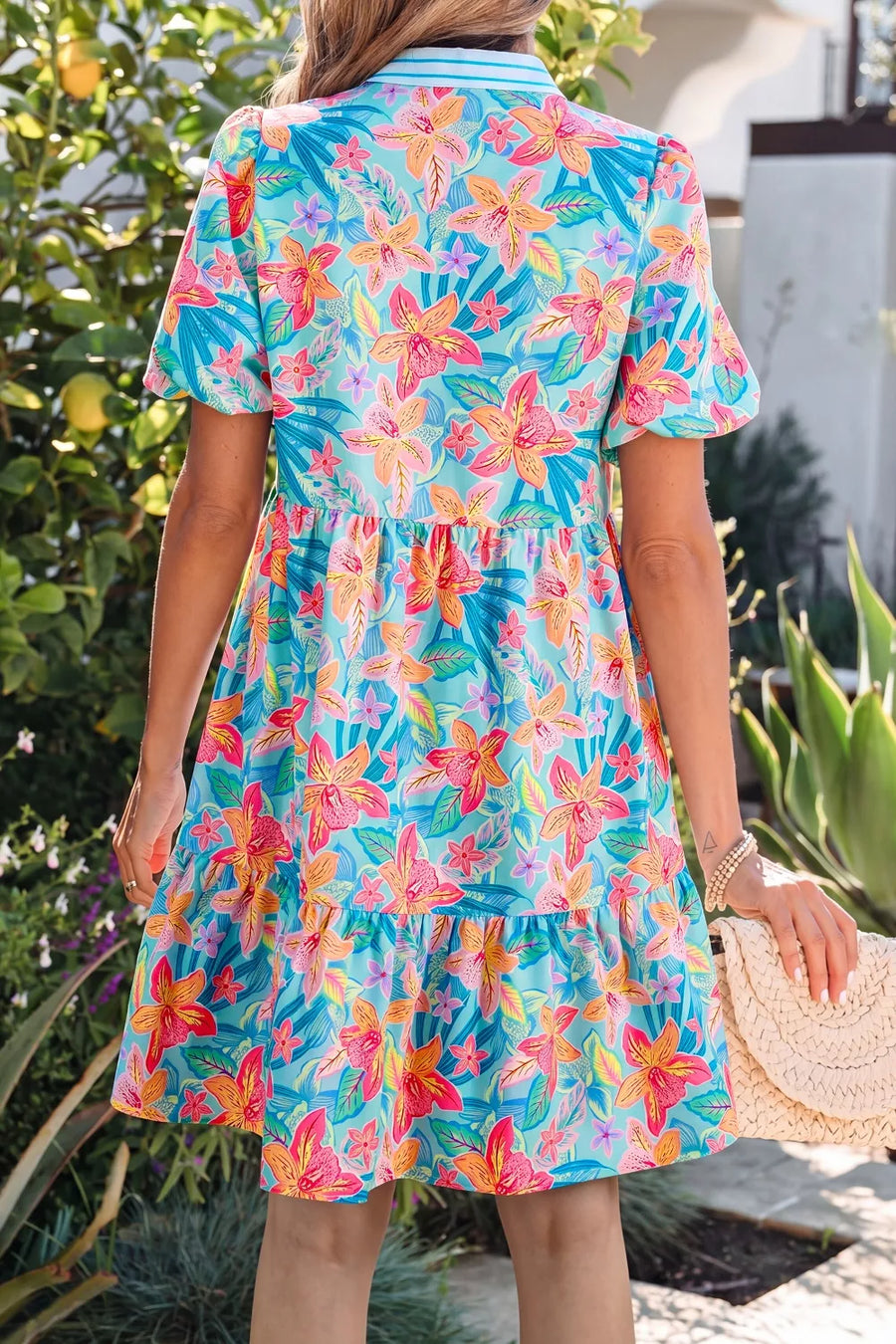 Woman wearing a colorful floral dress in an outdoor setting