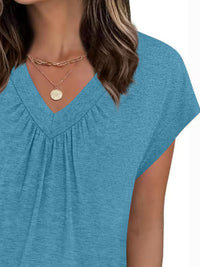 Blue top worn by a person with a plain background