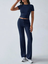 Person wearing a navy blue outfit with a top and pants on a white background