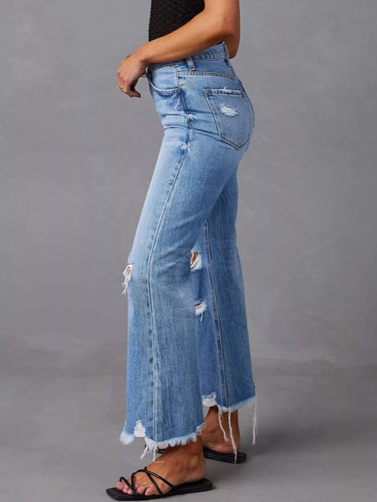 A side view of woman in Distressed Flare Jeans