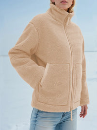 Person wearing a beige fleece jacket with a snowy background