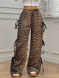 Leopard print pants with tie sides worn by a person indoors.