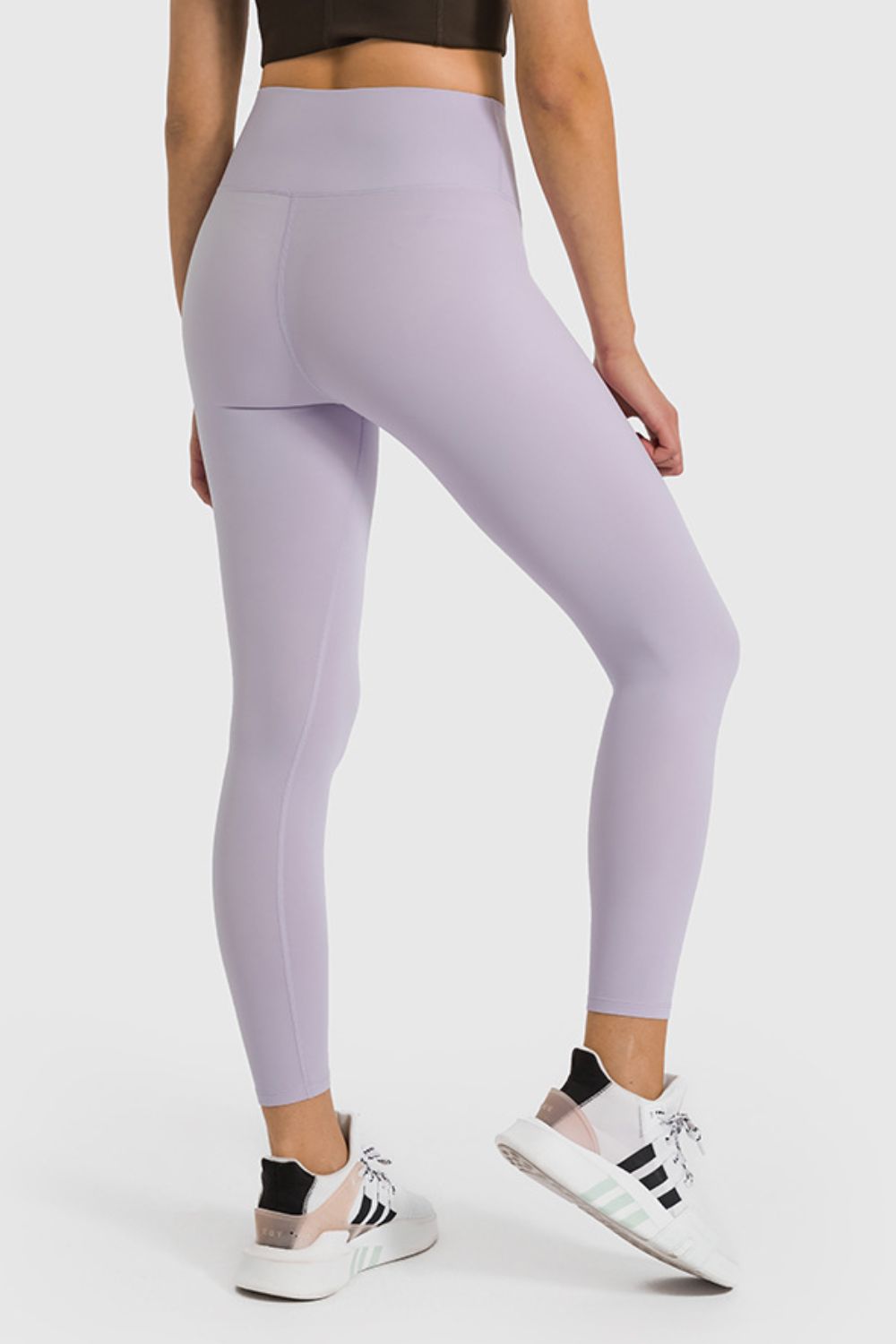 Person wearing lavender leggings with a white background