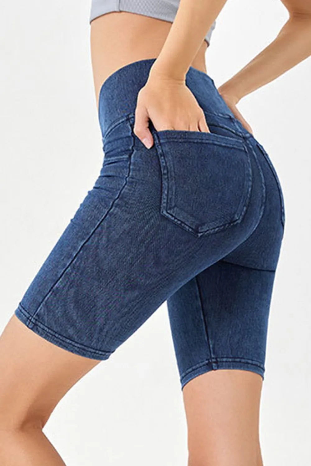 Blue denim shorts worn by a person on a white background